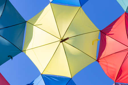 The sky is full of colorful umbrellas. Street with umbrellas in the sky in the village San Bartolome...