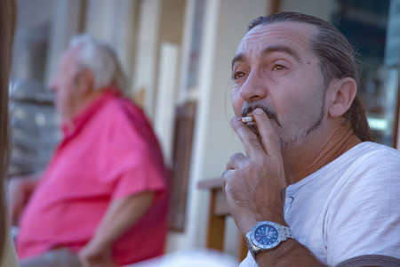 Huelva, Spain - August 17, 2020: Man is smoking a cigarette in a bar terraceのeditorial素材