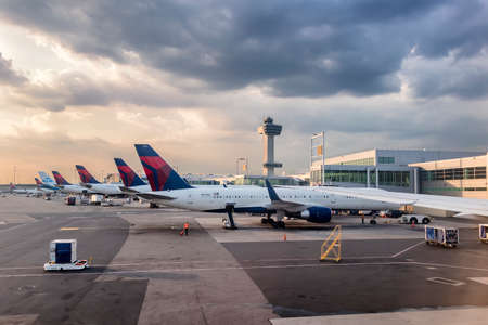 New York City, USA - June 7, 2017: Airplane window view showing airways planes in JFK nternational airport terminal and airport activity at sunsetのeditorial素材