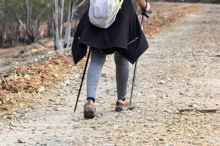 Hiker woman using a trekking poles, walking by a pathway of Rio Tinto river in Huelva, Andalusia, Spainの写真素材