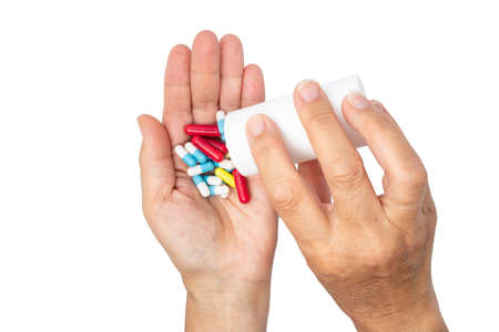 A woman pours the pills out of the bottle. hands with pills on, spilling pills out of bottle on...