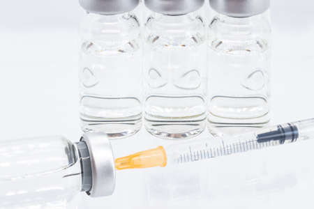 Vaccine vials and syringe isolated on white as vaccination conceptの写真素材