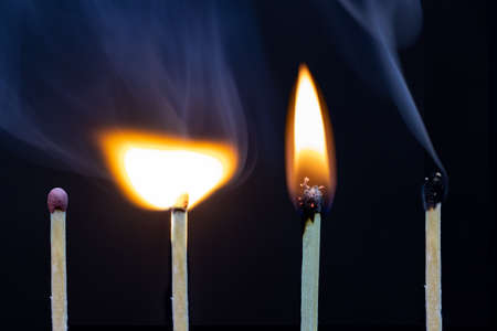 Matchstick on fire and extinguished isolated on black backgroundの写真素材