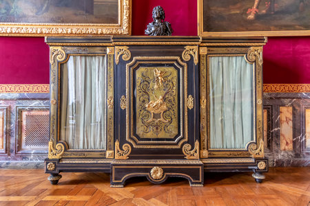 Versailles, France - March 14, 2018: Golden and mahogany furniture in the Royal Palace of Versailles...