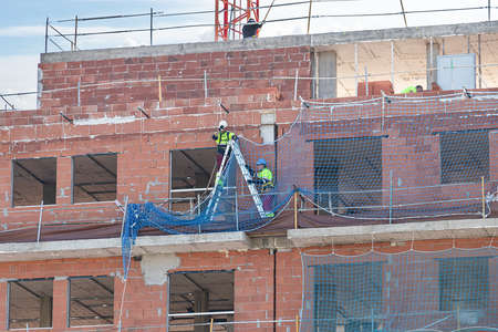 Huelva, Spain - March 11, 2021: Workers working in a new building under construction