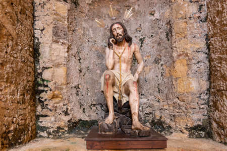 Medina-Sidonia, Cadiz, Spain - June 15, 2021: Ancient carving that represents Jesus Christ seated. Probably from the Middle Ages inside of the Church of Santa Maria in the town of Medina-Sidoniaのeditorial素材