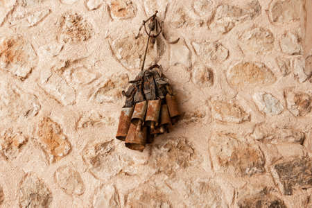 Rusty cowbells for Cattle hanging on a stone wallの写真素材