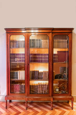 An old bookcase with books and glass doorsの写真素材