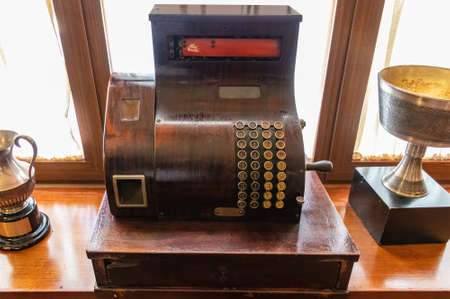 Old wooden cash register with round keypad and crankの写真素材