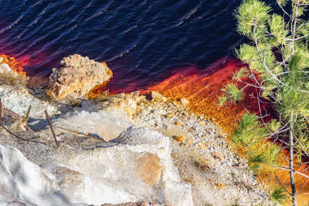 Detail of PeÃ±a del Hierro open mine pit with the red water due to copper and iron concentration. Deep excavation of pyrite and extraction of minerals of copper and gold in municipality of Nervaの写真素材