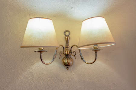 Antique pair of wall lamps over a white wallの写真素材