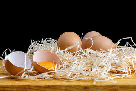 Fresh and raw eggs on a bed of straw