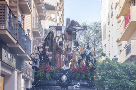 Huelva, Spain - April 15, 2022: Throne or platform of Descendimiento (descent) in procession by the narrow streets of the city. Soft focus due to the smoke of censeのeditorial素材