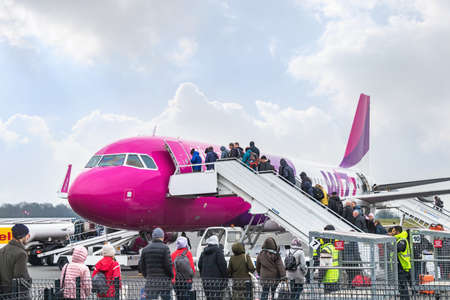 Paris, France - March 19, 2018: People boarding in a low cost fly from Viva Air airline, a pink...