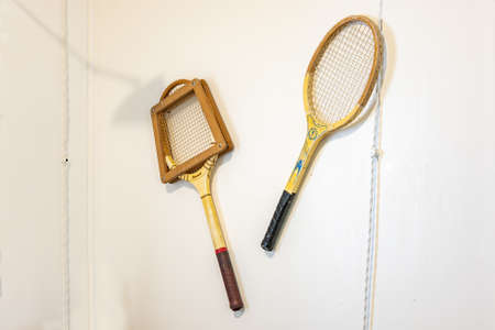 Punta Umbria, Huelva, Spain - April 27, 2022: Two old tennis rackets hanging on a wall Inside of an...