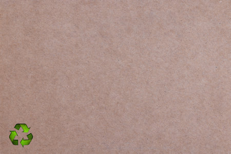 Brown Cardboard with three green arrows going in a triangle, international recycle symbol. Paper or cardboard eco friendlyの写真素材