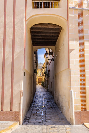 Narrow street in old Seville city center, in Santa Cruz neighbourhood, Andalusia, Spainの写真素材