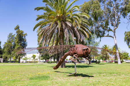 Huelva, Spain - April 28, 2022: Partial view of the monument to a dragonfly made in corten steel, in the Campus of âEl Carmenâ of the Huelva University. Backlight and low angle view photographyのeditorial素材