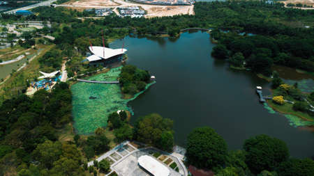A man made lake in a public park in Malaysia taken by a drone surrounded by trees and greenery