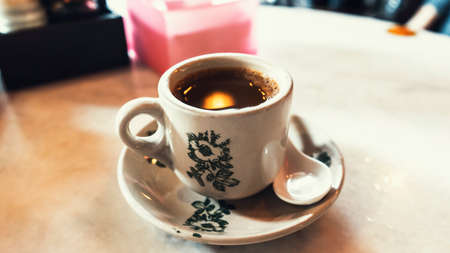 A cup of hot coffee at a kopitiam in a white porcelain cupの写真素材