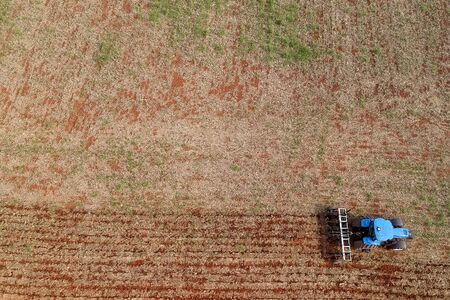 Aerial view of a tractor harrowing the soil to plant soybeans in Brazilの写真素材