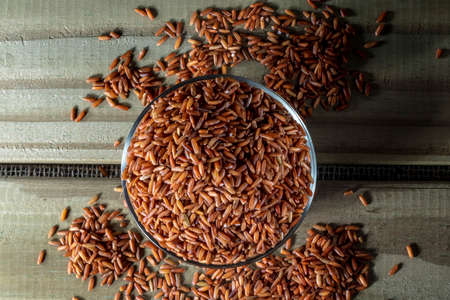 red rice on glass bowl isolated on wooden table in Brazilの写真素材