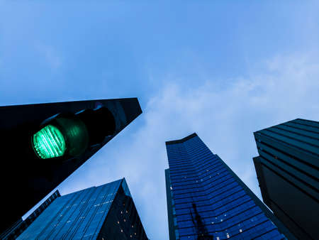 View of green street light and modern buildings with blue sky in Paulista Avenue, Brazilの写真素材