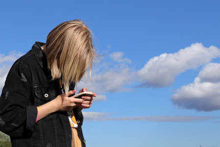 Teen girl playing online games by a smartphoneの写真素材