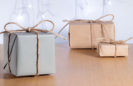 Christmas gifts in craft style on background of bokeh of lightsの写真素材
