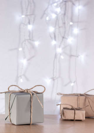 Christmas gifts in craft style on background of bokeh of lightsの写真素材