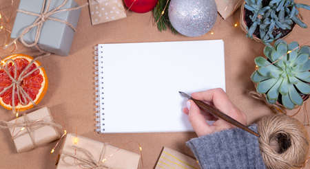 Woman holding calligraphic pen Christmas greeting card template in craft style. Empty paperの写真素材