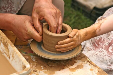 Close-up of hands making pottery on a wheel の写真素材