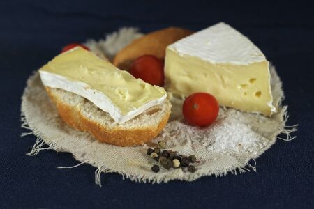Arrangement with piece of bread , tomatoes and white cheese on    blue backgroundの写真素材