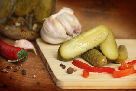 Glass jar with the cucumbers on a wooden table の写真素材