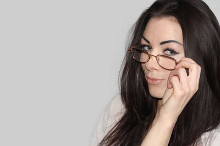 Portrait of a beautiful young woman standing against grey backgroundの写真素材