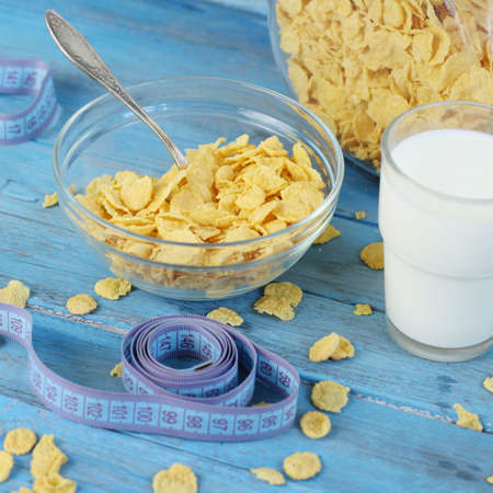 Cornflakes in bowl with milk on blue  wooden background.の写真素材