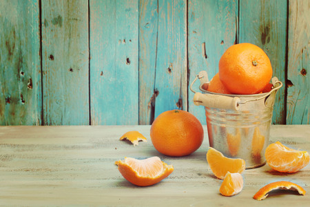 Bowl of mandarins on old blue wooden background の写真素材