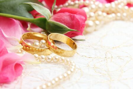 pair of wedding rings with roses for background imageの写真素材