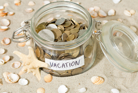 Savings for vacation. Coins and shell at the beachの写真素材