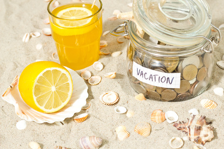 Savings for vacation. Coins and shell at the beachの写真素材