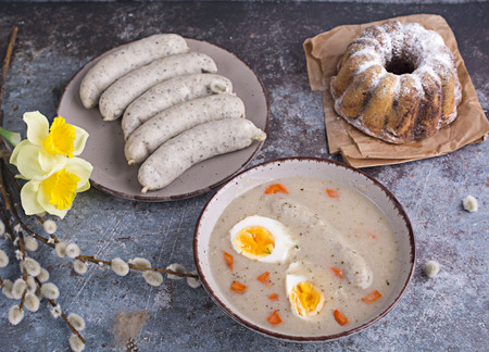 Easter breakfast. Sour rye soup with eggs and sausageの写真素材