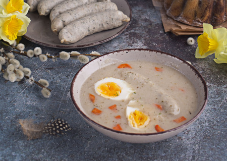 Easter breakfast. Sour rye soup with eggs and sausageの写真素材