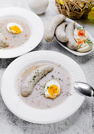 Easter breakfast. Sour rye soup with eggs and sausageの写真素材