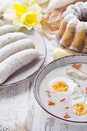 Easter breakfast. Sour rye soup with eggs and sausageの写真素材
