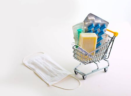 variety of pills in a supermarket trolley on white backgroundの写真素材