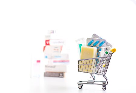 variety of pills in a supermarket trolley on white background