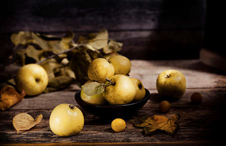 Wild, yellow apple on wooden background