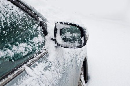 car covered with snow in the parkingの写真素材