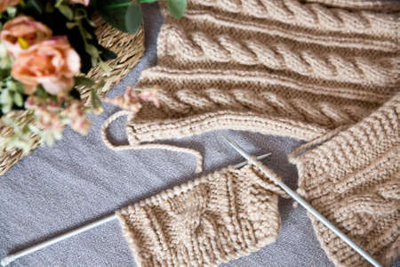 A piece of knitting with ball of yarn and a knitting needles. Knitting project in progress.の写真素材