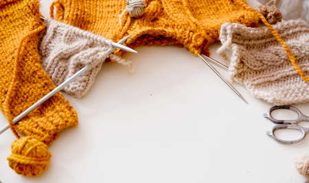 A piece of knitting with ball of yarn and a knitting needles. Knitting project in progress.の写真素材